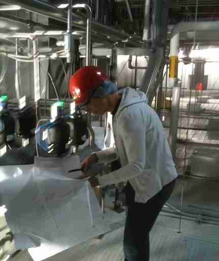 Carola in the field, checking CAD drawings for a process engineering plant
